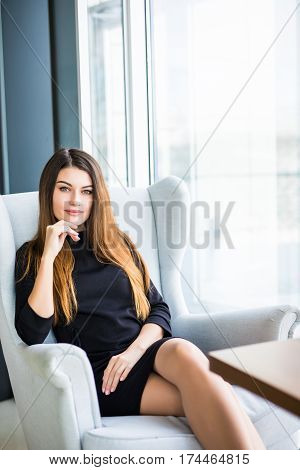 Attractive young woman sitting on a chair in a cafe