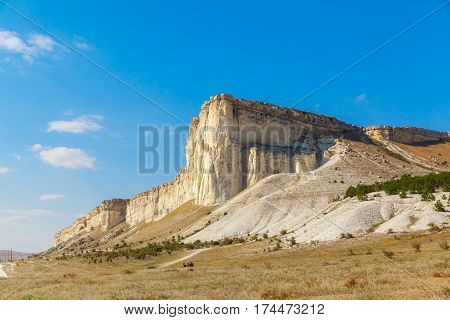 View of White rock or Aq Qaya on a Sunny summer day. Crimea. White limestone with a vertical cliff