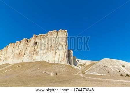 View of White rock or Aq Qaya on a Sunny summer day. Crimea. White limestone with a vertical cliff