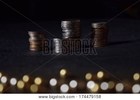 Coin stack on white background and bokeh on bottom of image.