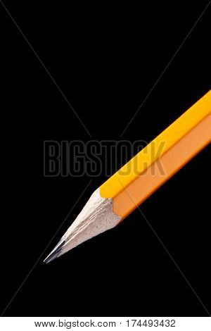 Wooden orange pencil isolated on black background. School and education. Drawing and painting. Artist.