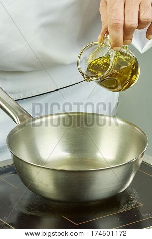 Chef pours oil into the pan for cooking