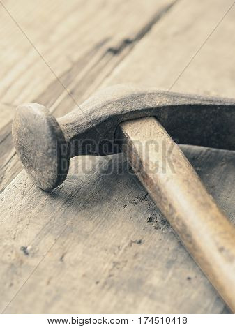 Old used vintage hammer on a wooden workbench