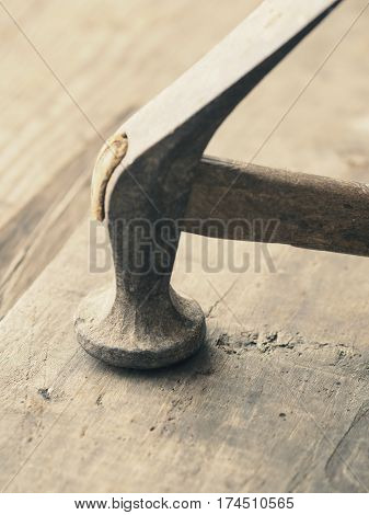 Old used vintage hammer on a wooden workbench
