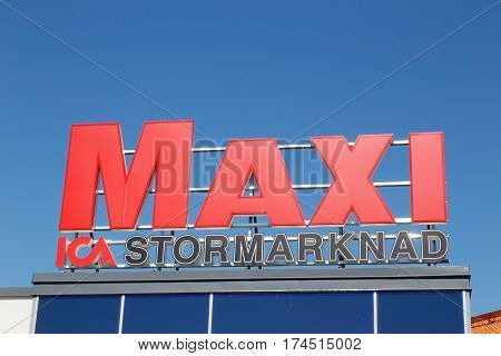 Solna Sweden - August 3 2016: Closeup of the roof sign at the supermarket Ica Maxi against a blue sky.
