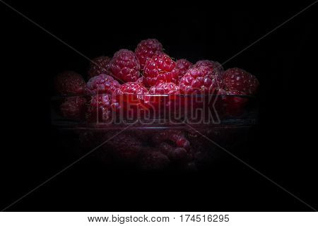 Fresh raspberries isolated on black bg textured