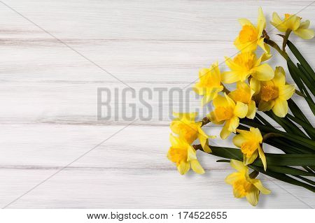 Greeting Card for Easter Mother's Day Birthday March 8. Beautiful background with yellow jonquil flowers on wooden texture.Top view Flat lay. Horizontal Image With Copy Space