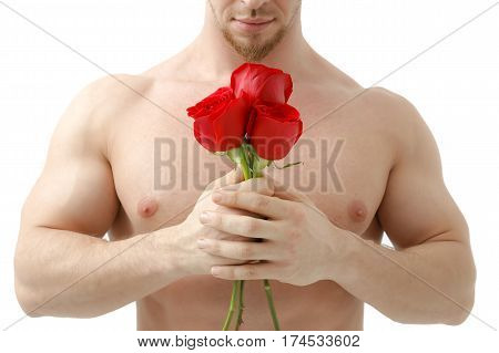 Handsome man holding a red rose and a bouquet of red roses. Sexy man gives a rose on a white background with a beautiful light. Isolated on white background