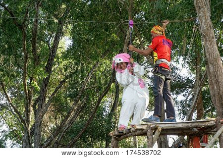 Labuan,Malaysia-Feb 12,2017:Happy girl in teddy bear costume enjoying on a zipline in Labuan,Malaysia.There will be more ziplines in Malaysia,especially when there have so much natural resources & rainforest.