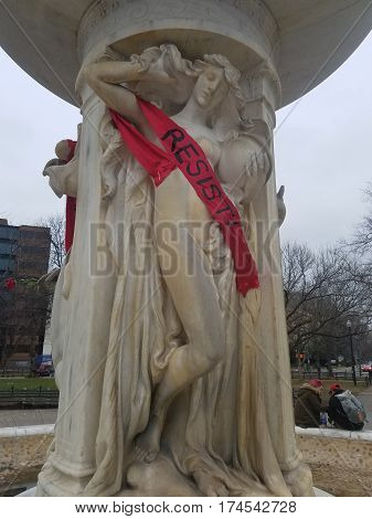 WASHINGTON, DC - JANUARY 21, 2017: Banner with the Resist hashtag, wrapped around a statue in the DuPont circle during the Women's March on Washington protests for social justice.