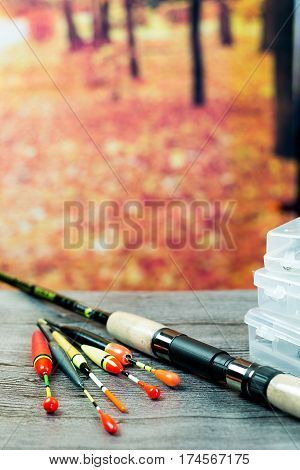 fishing rod with acsessories on the grey wooden table at autumn background