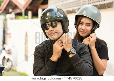 Young Adult Asian Couple Male and Female Biker or Motorcyclist Wearing Safe Helmet before Travel on Motorcycle as Accident Prevention or Safety Riding Concept.