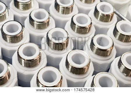 Plumbing connection fittings for plastic pipes. Orderly arranged in neat rows. Abstract industrial background.