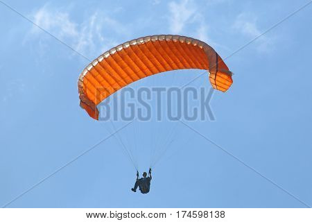 Paraglider using big ears to descend his wing