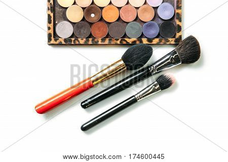Makeup collection brushes and shadows isolated white background Close-up