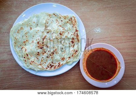 Roti canai or roti Prata with curry sauce.This is the famous authentic recipe used by the Indians in Malaysia.