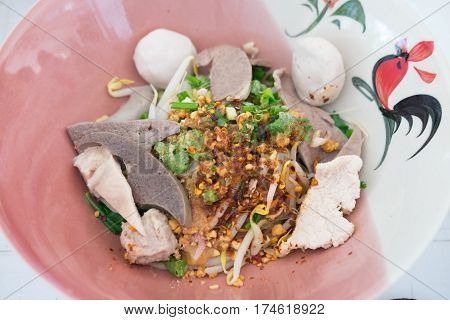 Thai Fusion Food dry noodle with pork in ceramic bowl with Thai style spice