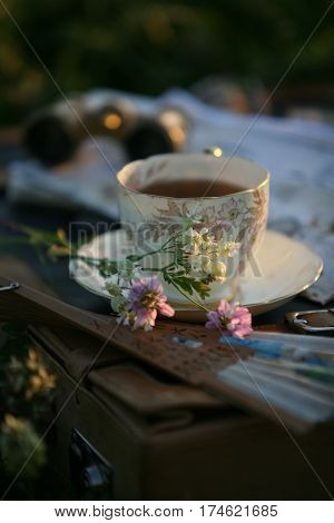a cup of tea in the sunset light and pearl operaglasses