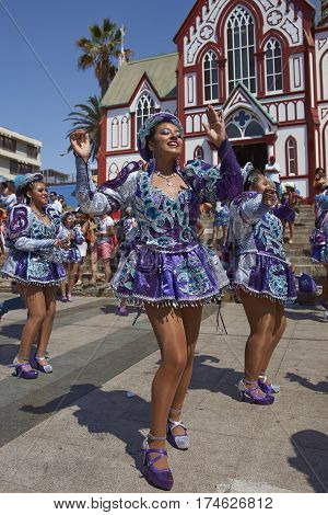 ARICA, CHILE - FEBRUARY 10, 2017: Female members of a Caporales dance group in ornate costumes performing at the annual Carnaval Andino con la Fuerza del Sol in Arica, Chile.