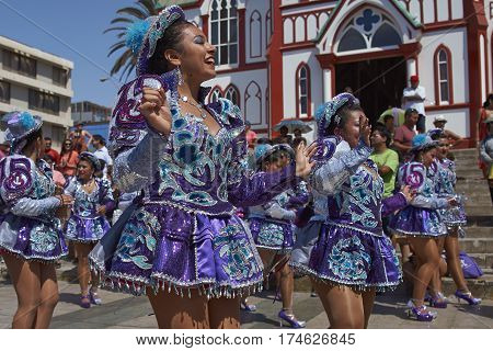 ARICA, CHILE - FEBRUARY 10, 2017: Female members of a Caporales dance group in ornate costumes performing at the annual Carnaval Andino con la Fuerza del Sol in Arica, Chile.