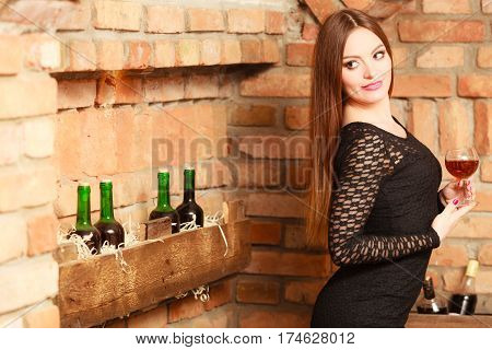 Woman Tasting Wine In Rural Cottage Interior