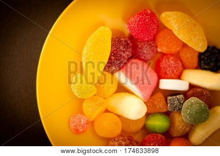 colored fruit candies on a yellow plate