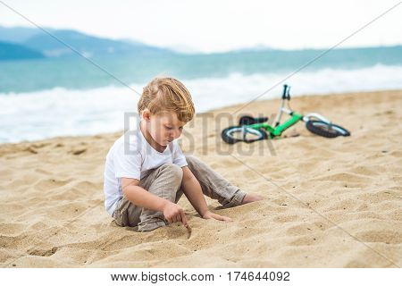 Active Blond Kid Boy And Bicycle Near The Sea. Toddler Child Dreaming And Having Fun On Warm Summer