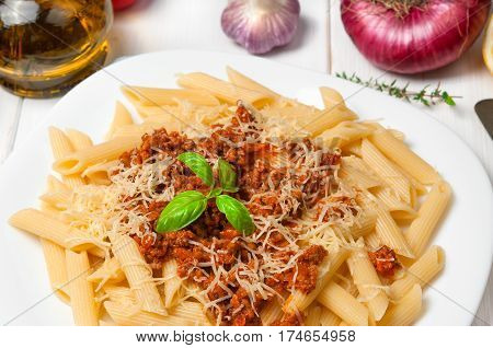 Spaghetti pasta bolognese with ingredients on white wooden background surface. Top view