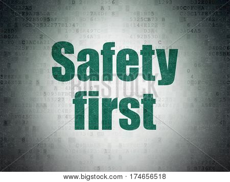 Security concept: Painted green word Safety First on Digital Data Paper background
