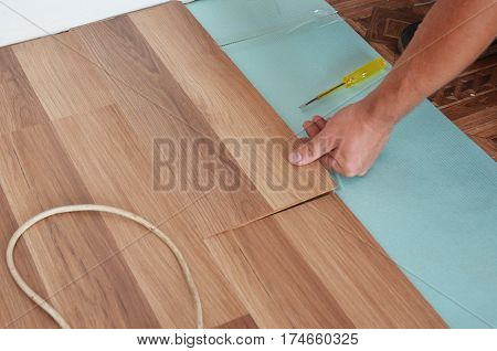 Man Installing New Laminate Wood Flooring. Installing wooden laminate flooring. Step by Step.