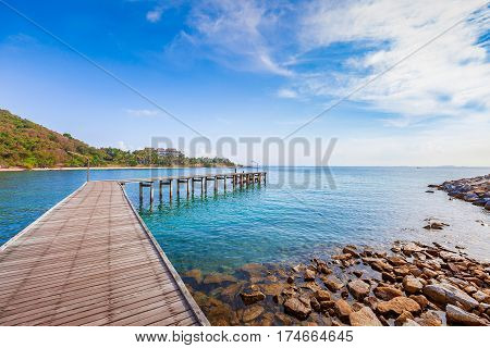 Wooden plank pier with seascape and bright blue sky for relax time at Khao Leam Ya National Park Rayong Province Thailand