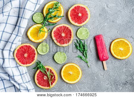 homemade citrus popsicles with fresh fruit slices on stone table background top view