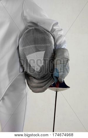 Female fencer hold epee and ferncer mask wearing white fencing costume isolated on white background