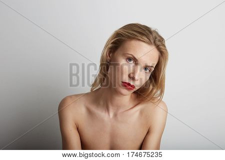Portrait of beautiful young woman with blonde hair wearing red lipstick.