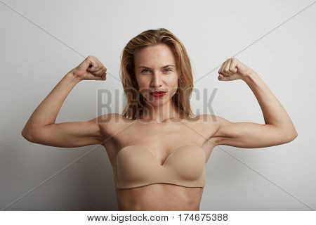 Portrait of beautiful young woman with blonde hair wearing nude bra.