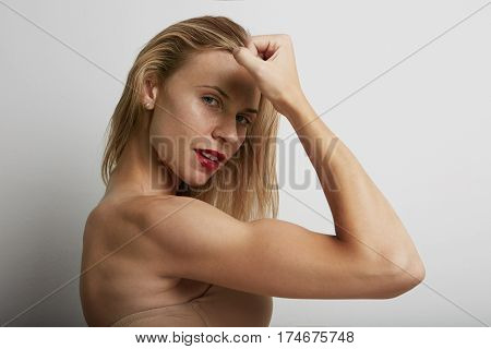 Portrait of beautiful young woman with blonde hair wearing nude bra.