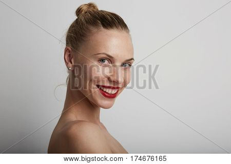 Portrait of beautiful smiling young woman. Wearing nud make-up.