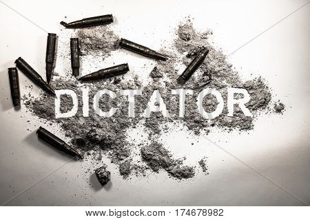 Dictator word written in grey ash dirt dust with bullets around as dictatorship power war revolution tyranny bad government or political system concept lent background