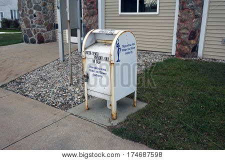 MANCELONA, MICHIGAN / UNITED STATES - NOVEMBER 27, 2016: One may deposit payments for one's water and sewer bill into a white box in front of the Mancelona Village Offices building on State Street in downtown Mancelona.