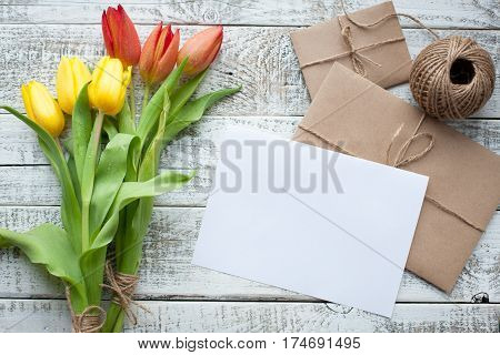 Fresh Yellow Tulips And Empty Tag On Teal Painted Wooden Background. Selective Focus. Place For Text