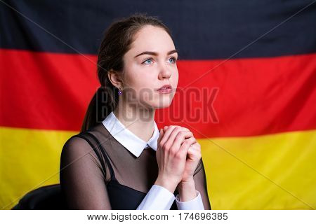 Portrait of a beautiful calm brunette girl in the background of the German flag