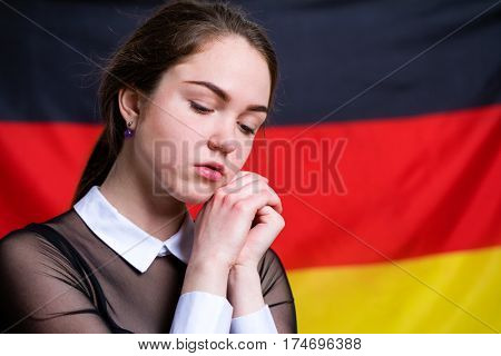 Portrait of a beautiful calm brunette girl in the background of the German flag