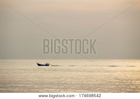 silhouette minimalist image of single local fishery boat sail on calm sea in sunrise with copy space