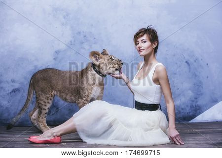 Beautiful Fashionable Young Woman With A Little Alive Lion Cub