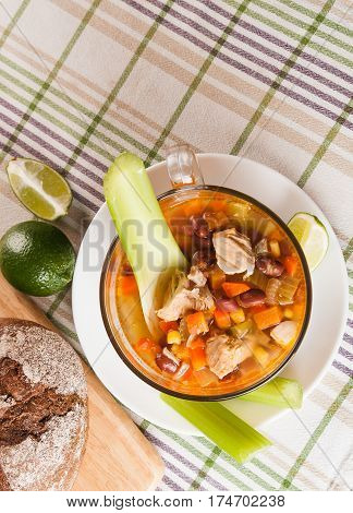 Mexican soup with chicken celery lime bread and vegetables top view