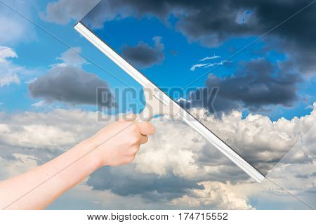 Cleaning window with rubber squeegee and cleaning the sky