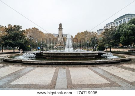 Madrid Spain - November 20 2016: Rainy day in Spain Square of Madrid. Fountain and Cervantes monument on background