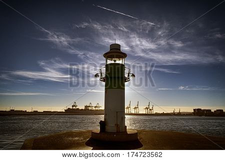AARHUS DENMARK - NOVEMBER 24 2016: Portside lighthouse in the port of Aarhus. Container Port is the largest in Denmark seen in the background November 24 2016