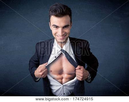 Businessman tearing off his shirt and showing mucular body concept on background