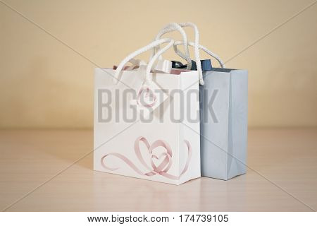 Blank Two Paper Gift Bag Mock Up Standing On A Wooden Table. Empty Plastic Package Mockup Stand On T
